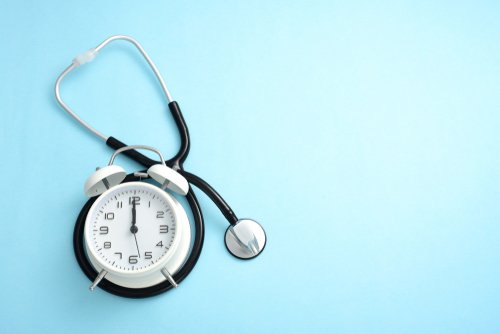 Stethoscope on blue background around clock