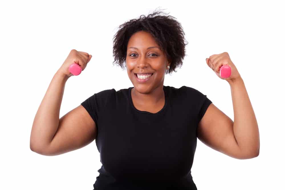 Cheerful woman exercising with pink dumbbells 