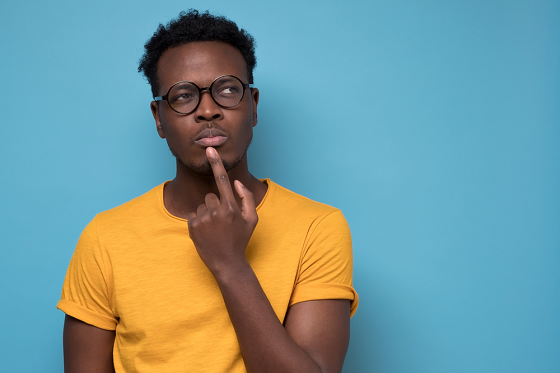 man in deep thoughts with his index finger on his lower lip