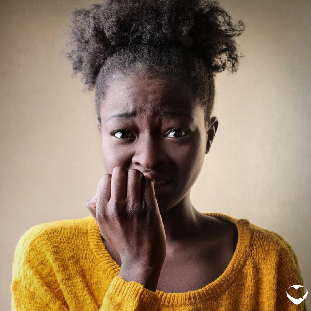 Girl with fingers in her mouth looking worried