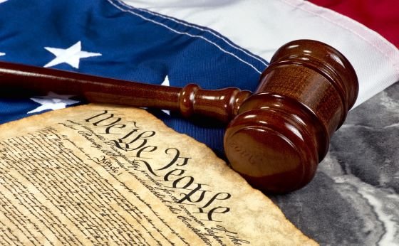 wooden gavel on top of American flag and Bill of Rights document