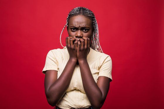 scared girl holding mouth with both palms