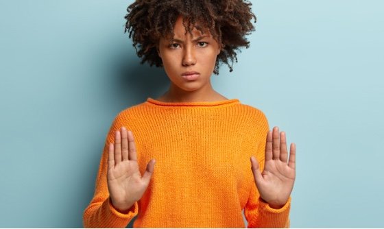 Woman holding her hands up as a way to push back