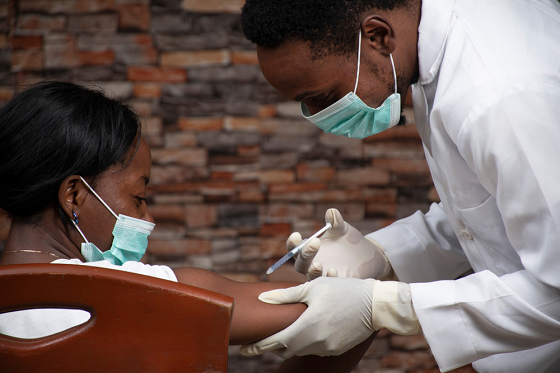 Male doctor injecting a female patient 