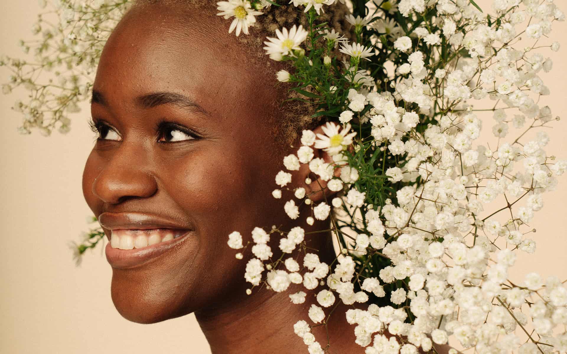 Happy young woman surrounded by white flowers 