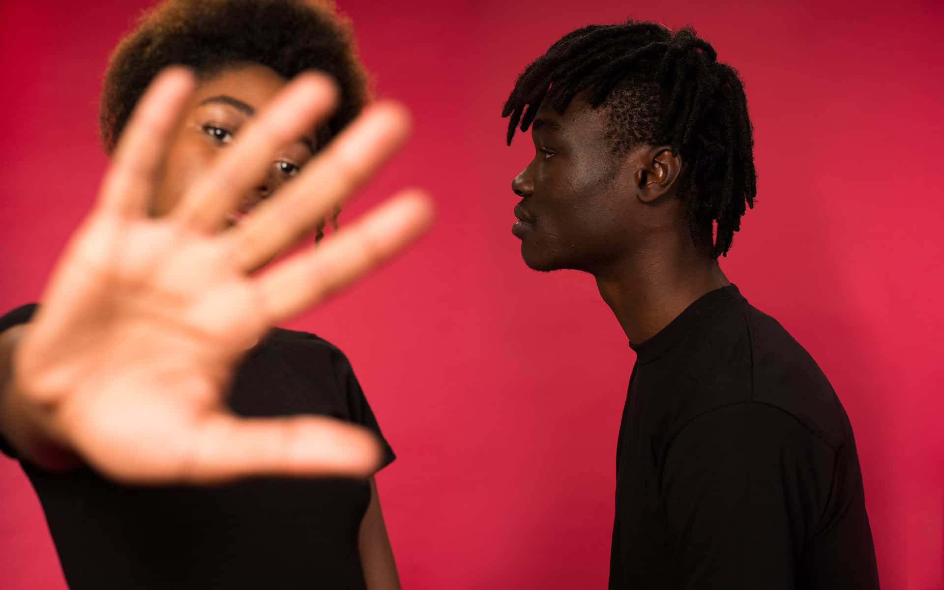 Couple fighting, her holding her hand up to cover the lens of the camera