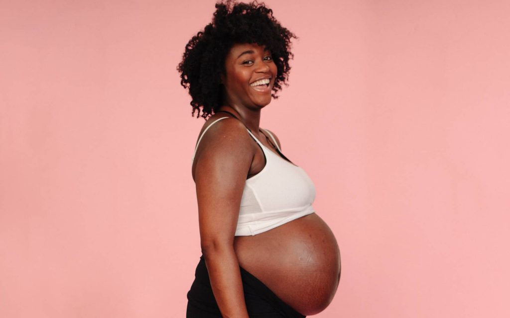 pregnant women holding her bare belly