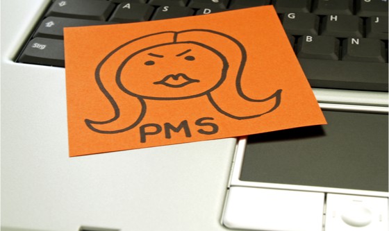 Sticky note with the word PMS on it on a keyboard