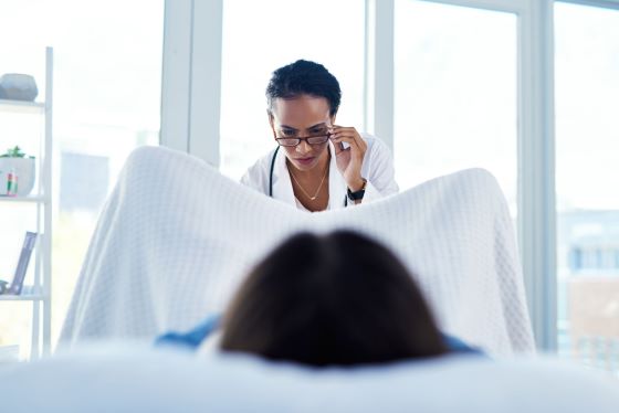 A female doctor examining a woman's vagina