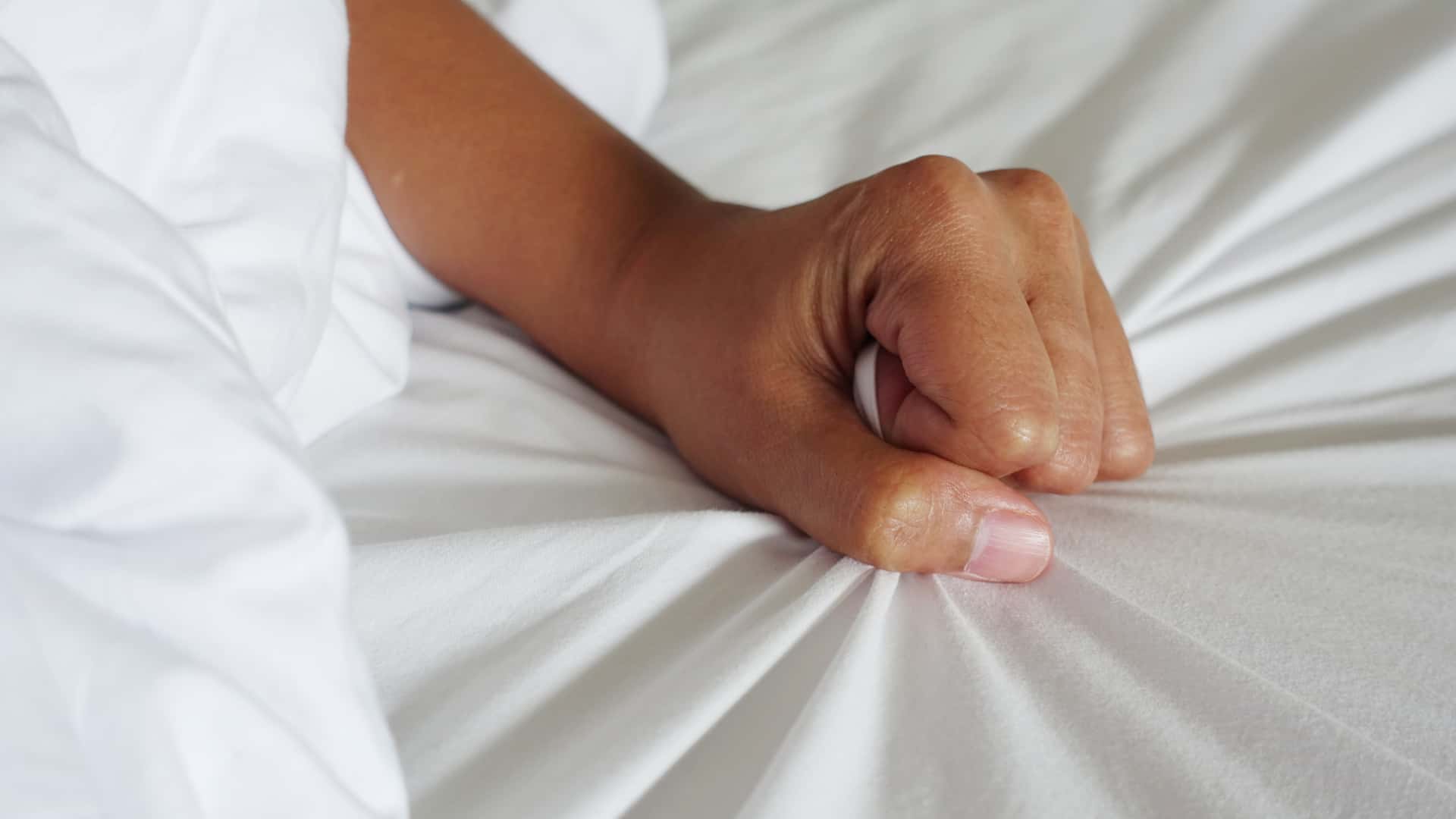 hand of women pulling white sheets in ecstasy