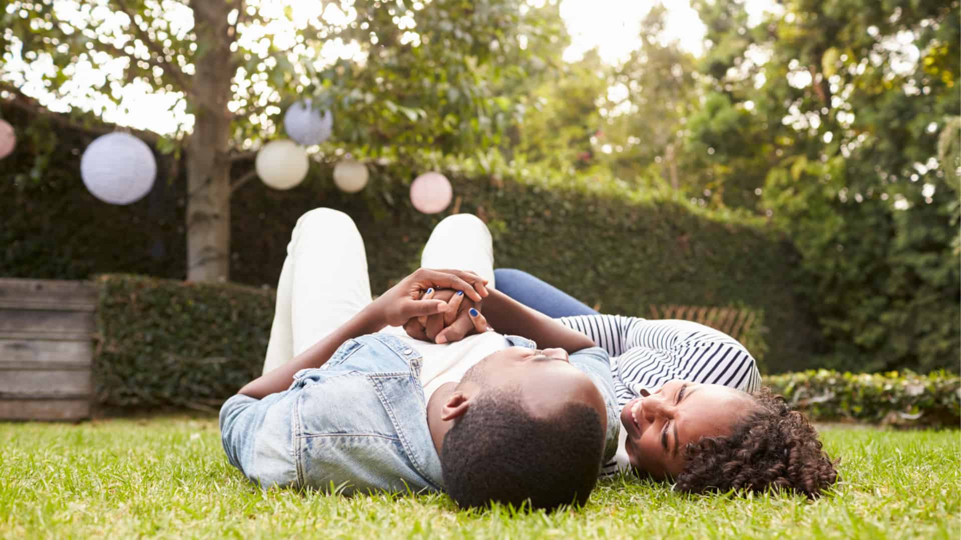 couple cuddled up on the grass outdoors.
