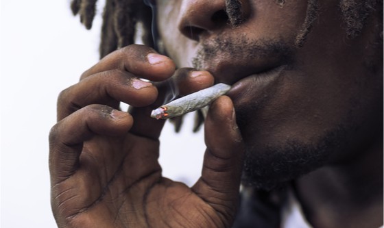 Man smoking a white paper joint close up