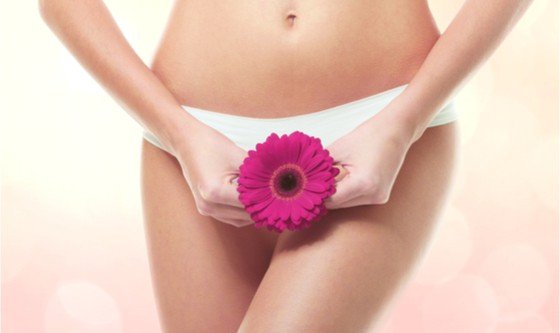 Woman holding flower in front of her underwear