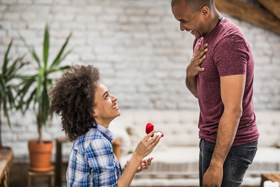 woman on her knees proposing to a man