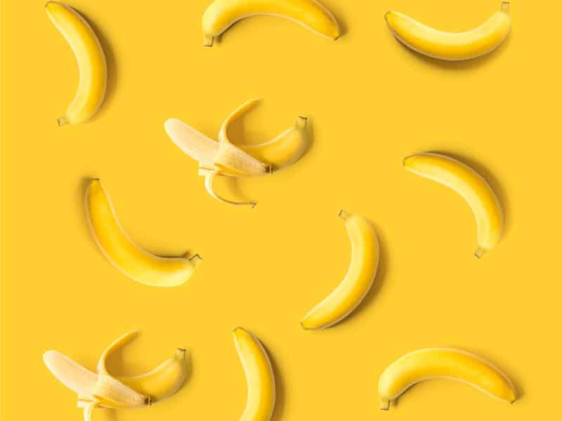 Yellow image of bananas, both peeled and unpeeled