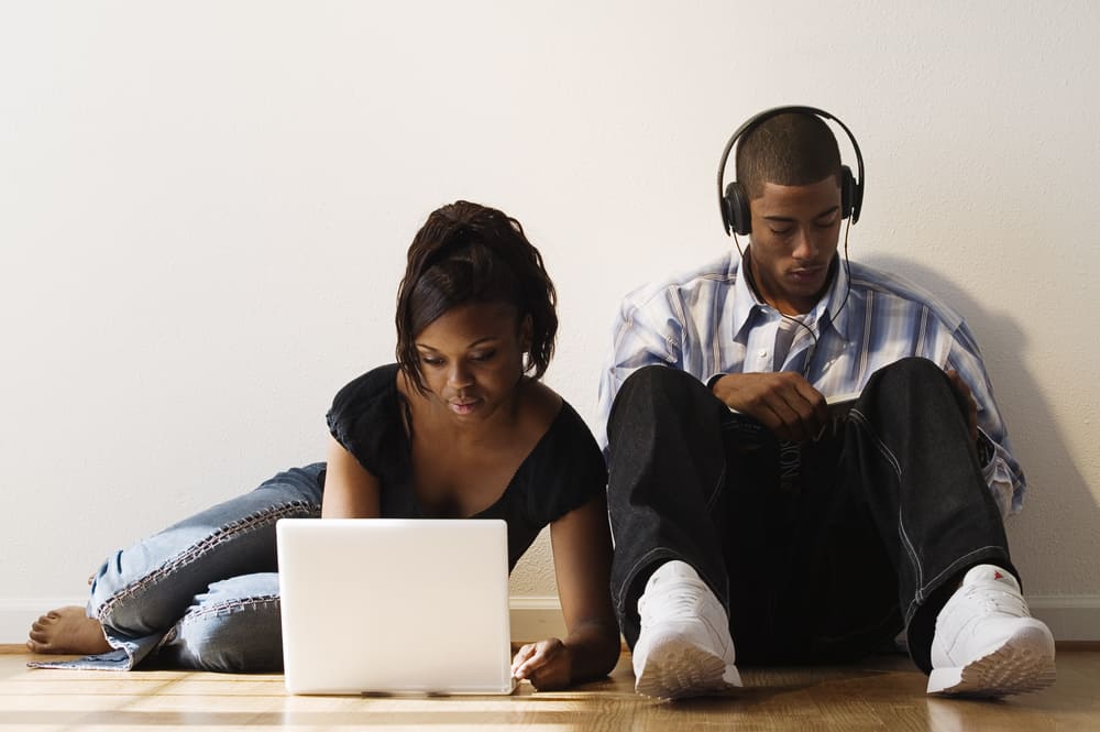 Young couple using laptop and headphones