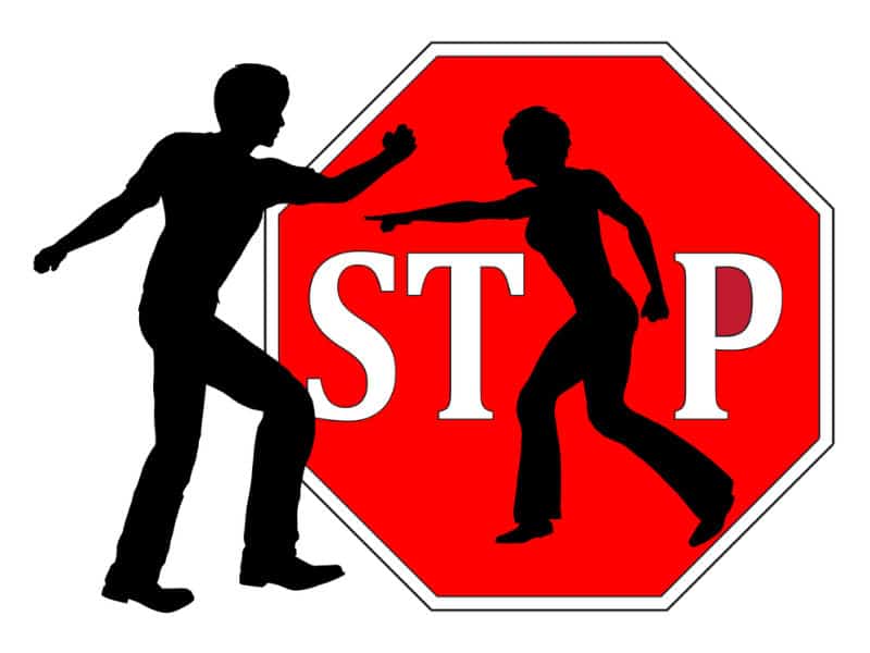 A stop sign with two humanoid figures fighting on it