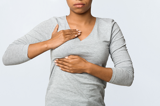 woman holding her breast with both hands