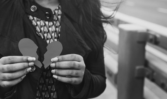 Woman holding broken paper heart