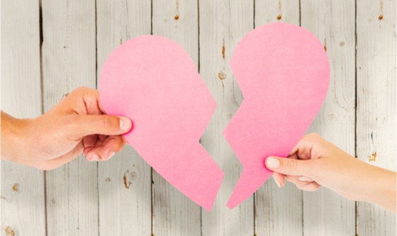 Image of two hands pulling apart a paper heart