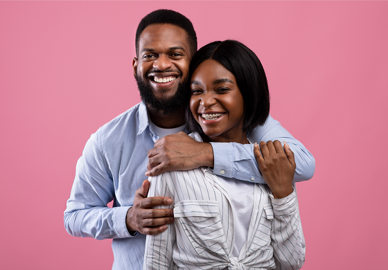 Happy couple with man hugging woman from behind