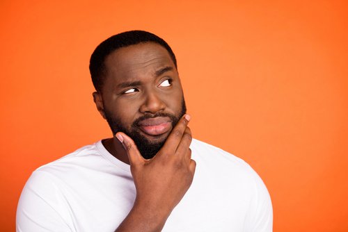 black man look empty space while holding chin