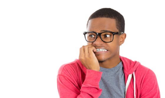 Embarrassed young man biting his nails 