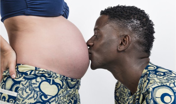 Expecting father kissing pregnant belly