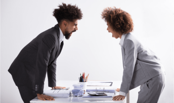 Couple yelling at each other across a desk