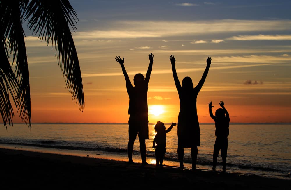 happy family with two kids having fun at sunset