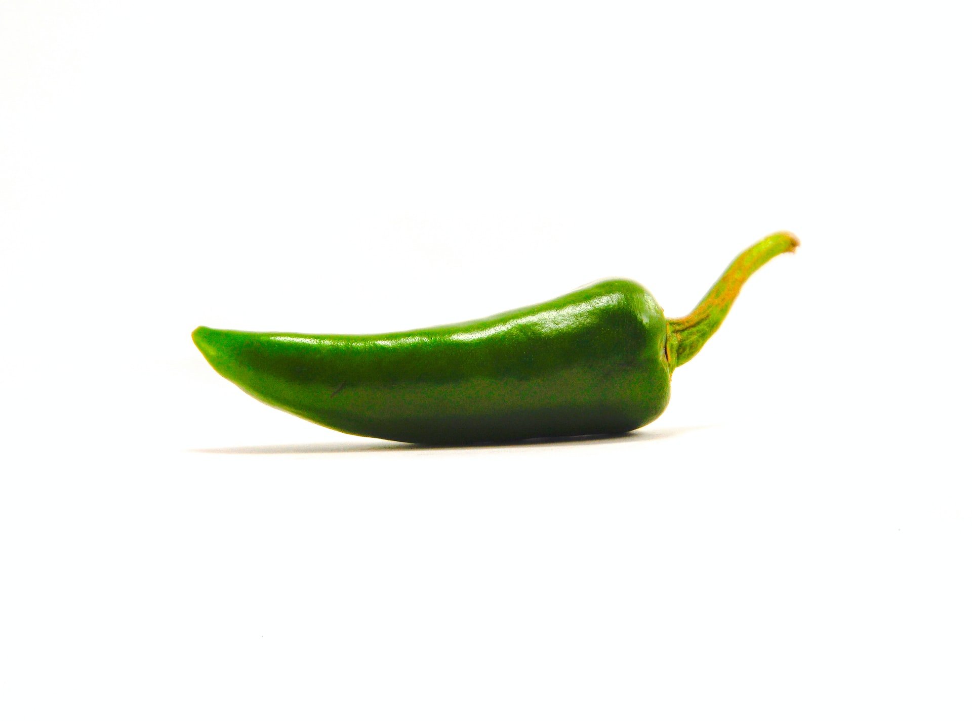 A picture of a green jalapeno chili on a white background