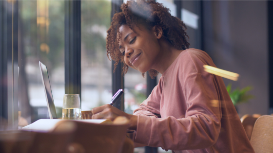 smiling woman writing a letter 