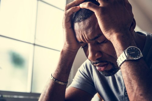 Black guy stressing and holding head with hands