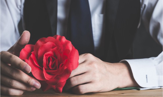 Man's hands, holding a red rose 