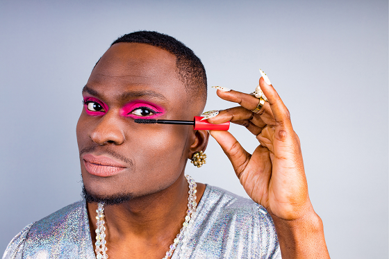 man applying pink eyeshadow with brush