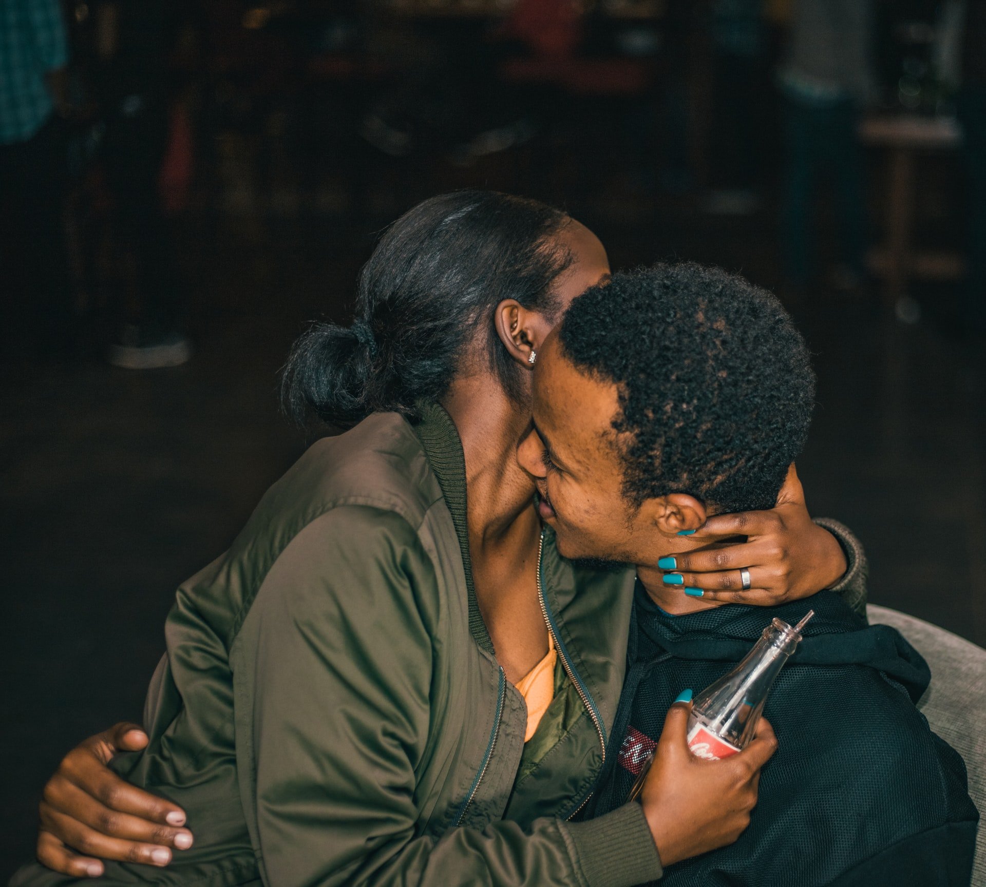 A couple sitting together in a bar, necking