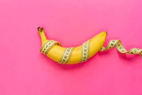 Yellow banana with measurement tape on pink background