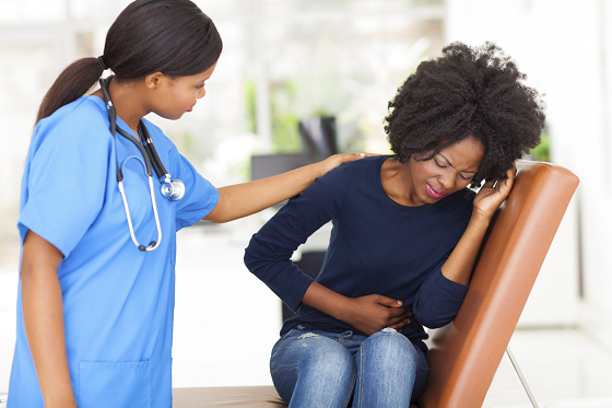 nurse consoles woman in pain leaning on a seat