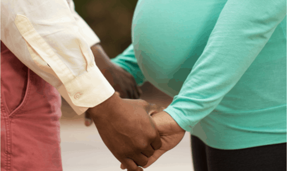 Pregnant woman holding hands with partner