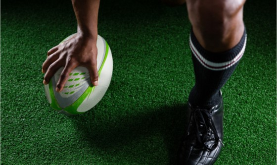Image of the foot of a rugby player with a ball 