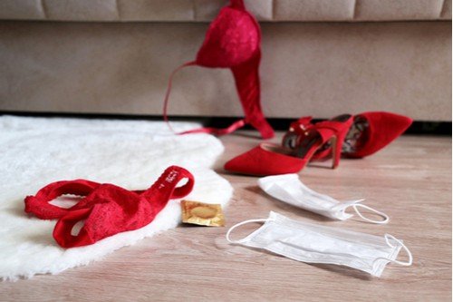 Red lace panties, bra, condom and two medical masks on the fur rug 
