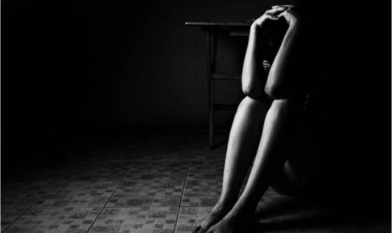 woman seated in a dark corner
