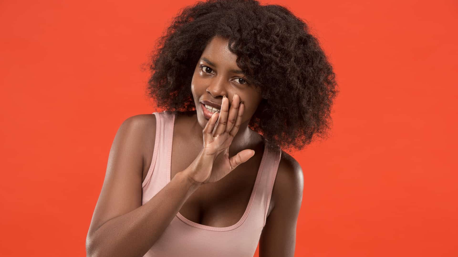  Young woman whispering a secret behind her hand