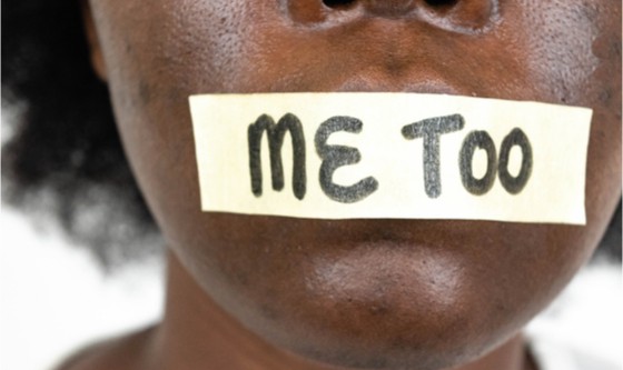 Woman with 'me too' tape covering her mouth, silencing her