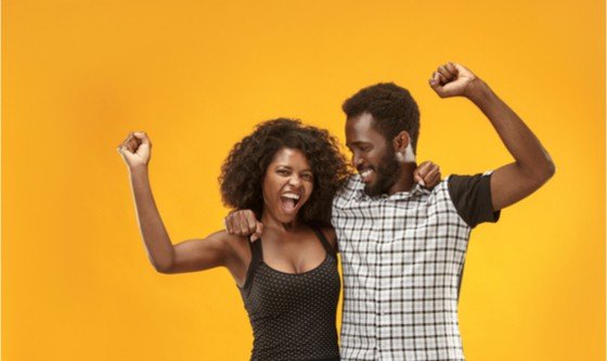 Happy couple celebrating in front of a yellow background