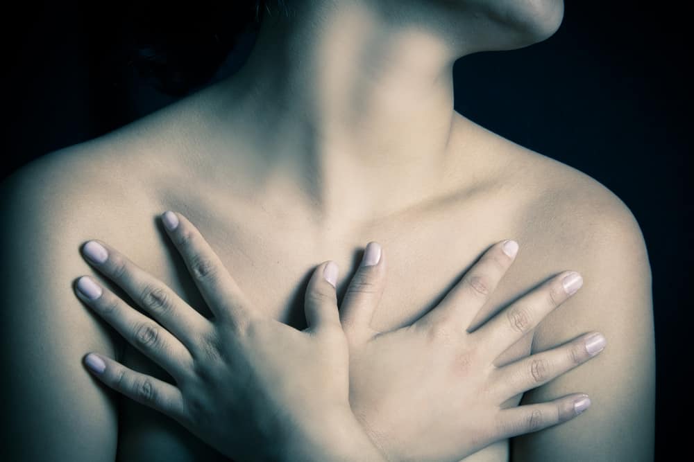 close up, topless woman body covering her breast with hand