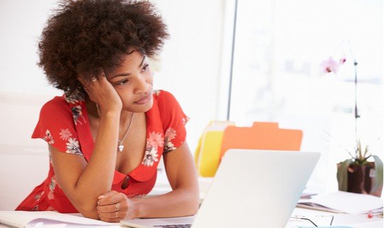 An African lady looking at her laptop, bored