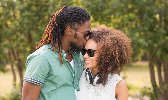 Couple kissing and cuddling in the park on a sunny day