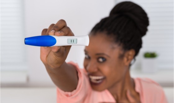 happy woman holding positive pregnancy test