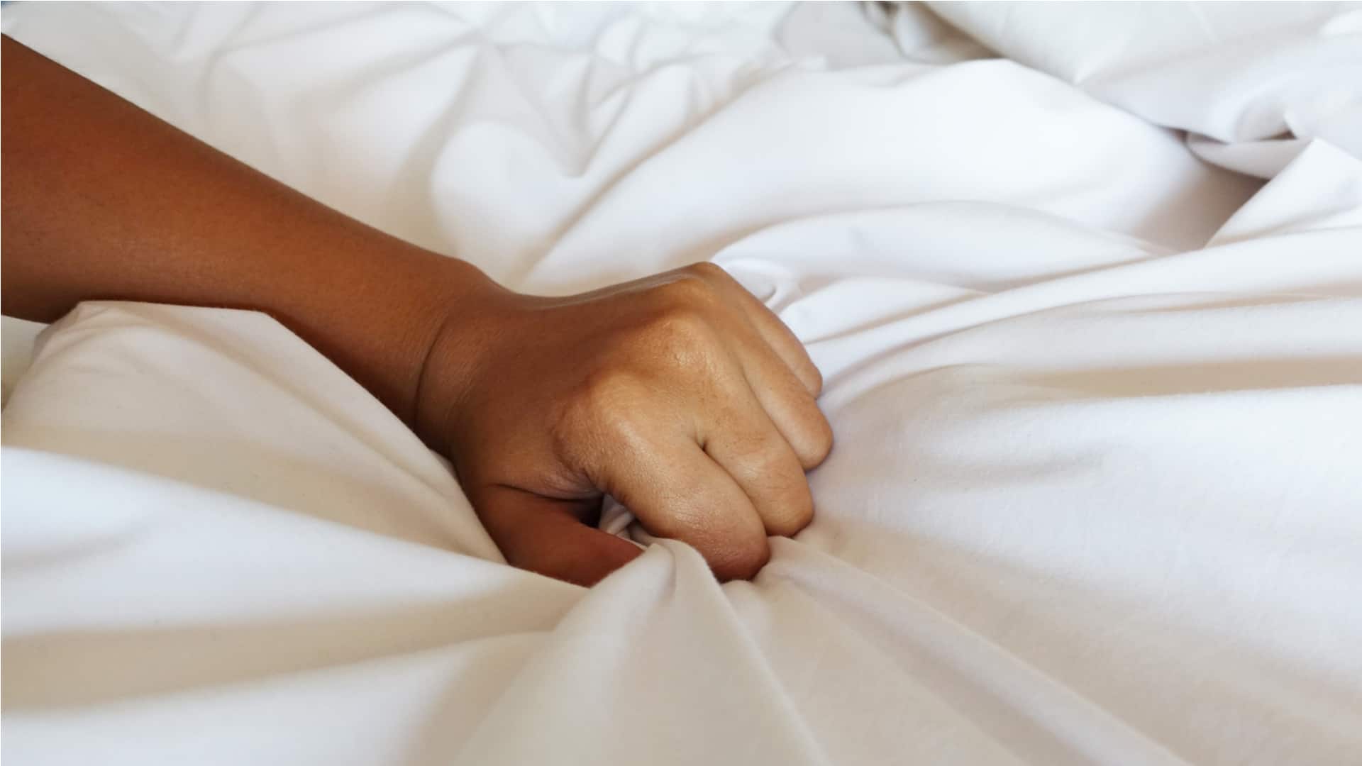 hand of women pulling white sheets in ecstasy, orgasm